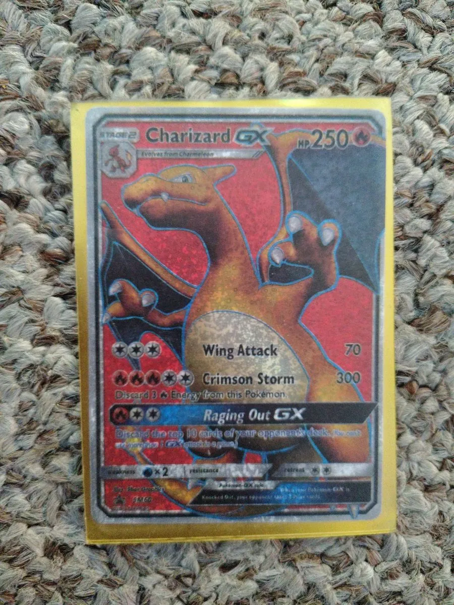 KNOWN FAKE — educational sample: counterfeit Charizard GX SM60 from the shop's October 2026 trade lot, photographed by the shop; gritty speckled print across the whole face